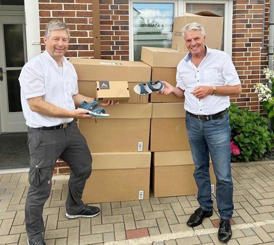 Foto mit Übergabe der Schuhe in vielen Kartons. Von Herrn Kreft an Dieter F. Kindermann.